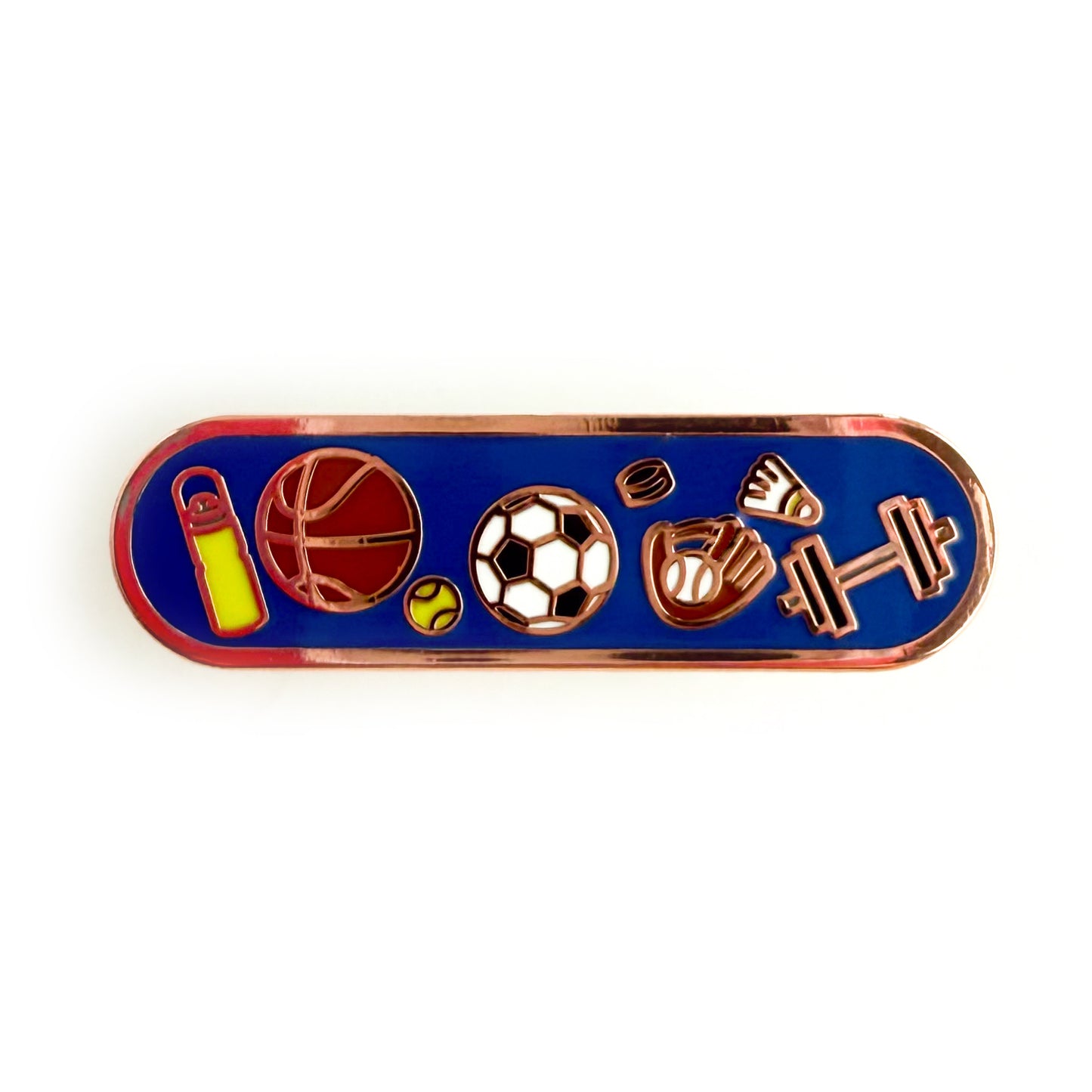 A bandaid shaped enamel pin with sport themed illustration on a blue background. There is a yellow water bottle, a basketball, a tennis ball, a soccer ball, a hockey puck, a baseball glove, a badminton birdie, and a dumbbell.