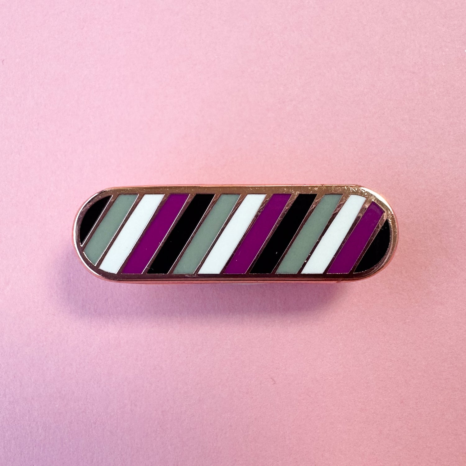 A bandaid shaped pin in the colors of the asexual or ace flag.