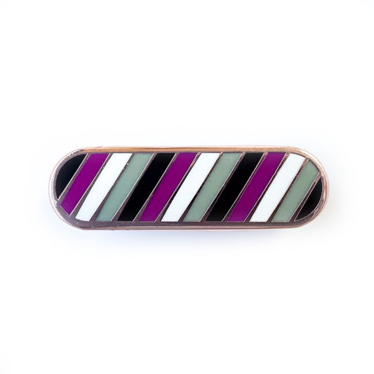 A bandaid shaped pin with diagonal bands of color on it in black, purple, white, and grey, representing the asexual flag.