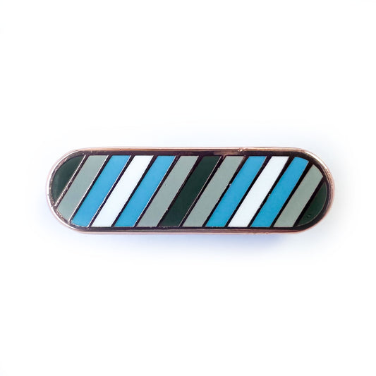 A bandaid shaped pin with diagonal stripes in grey, light grey, light blue, and white, which are the colors of the Demiboy Pride flag. 