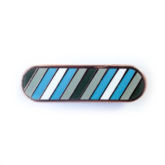 A bandaid shaped pin with diagonal stripes in grey, light grey, light blue, and white, which are the colors of the Demiboy Pride flag.