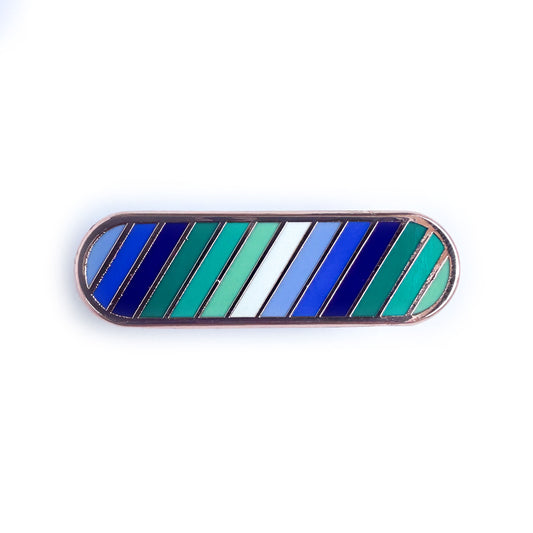 A capsule shaped pin in the colors of the Gay men flag in shades of blues and greens