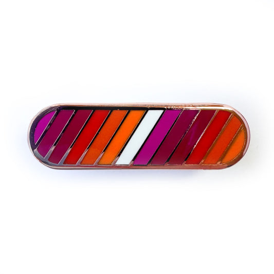 A capsule shaped pin with stripes in the colors of the Lesbian Pride Flag.