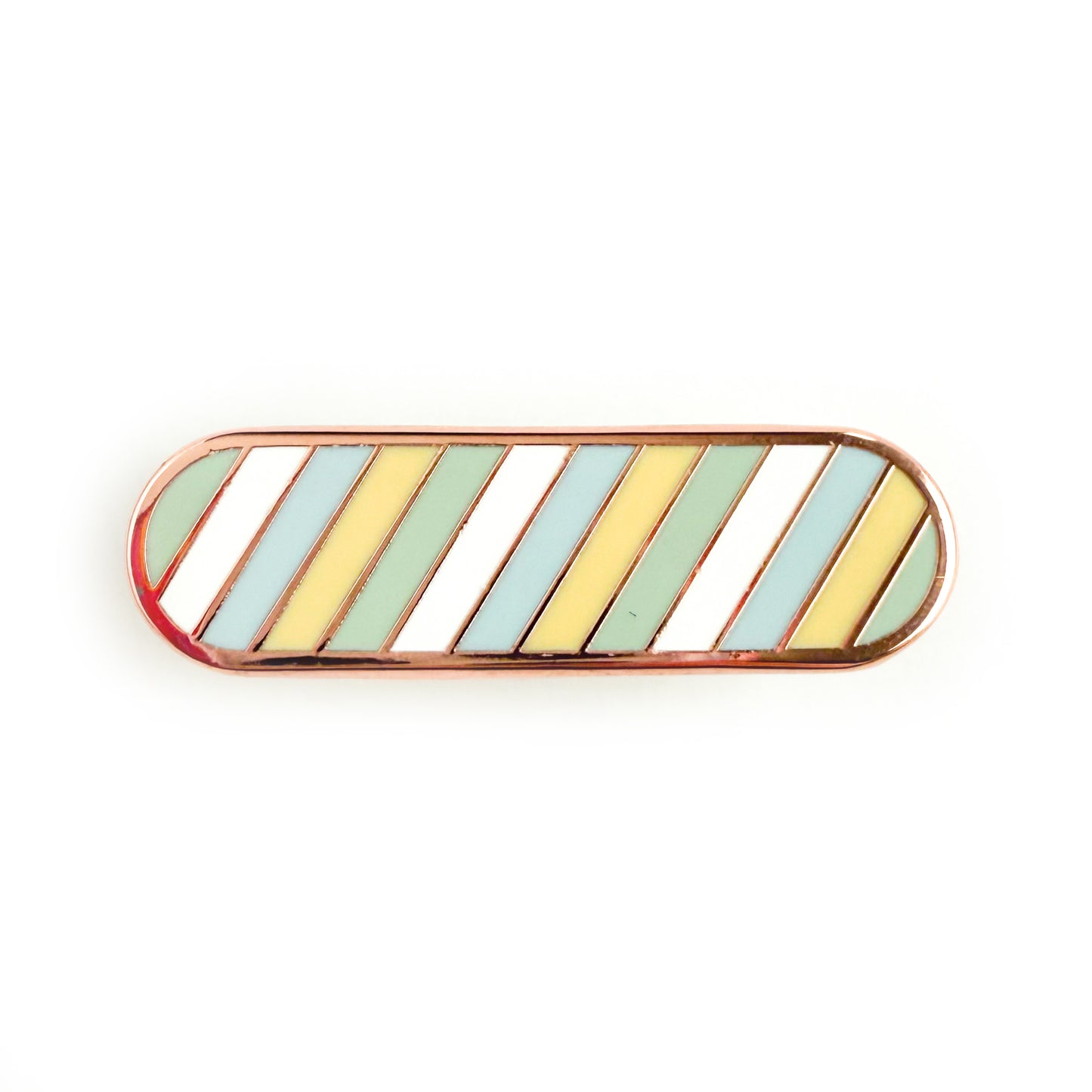 A bandaid shaped pin with diagonal bands of pastel color on it in blue, yellow, green, and white representing the unlabeled flag.