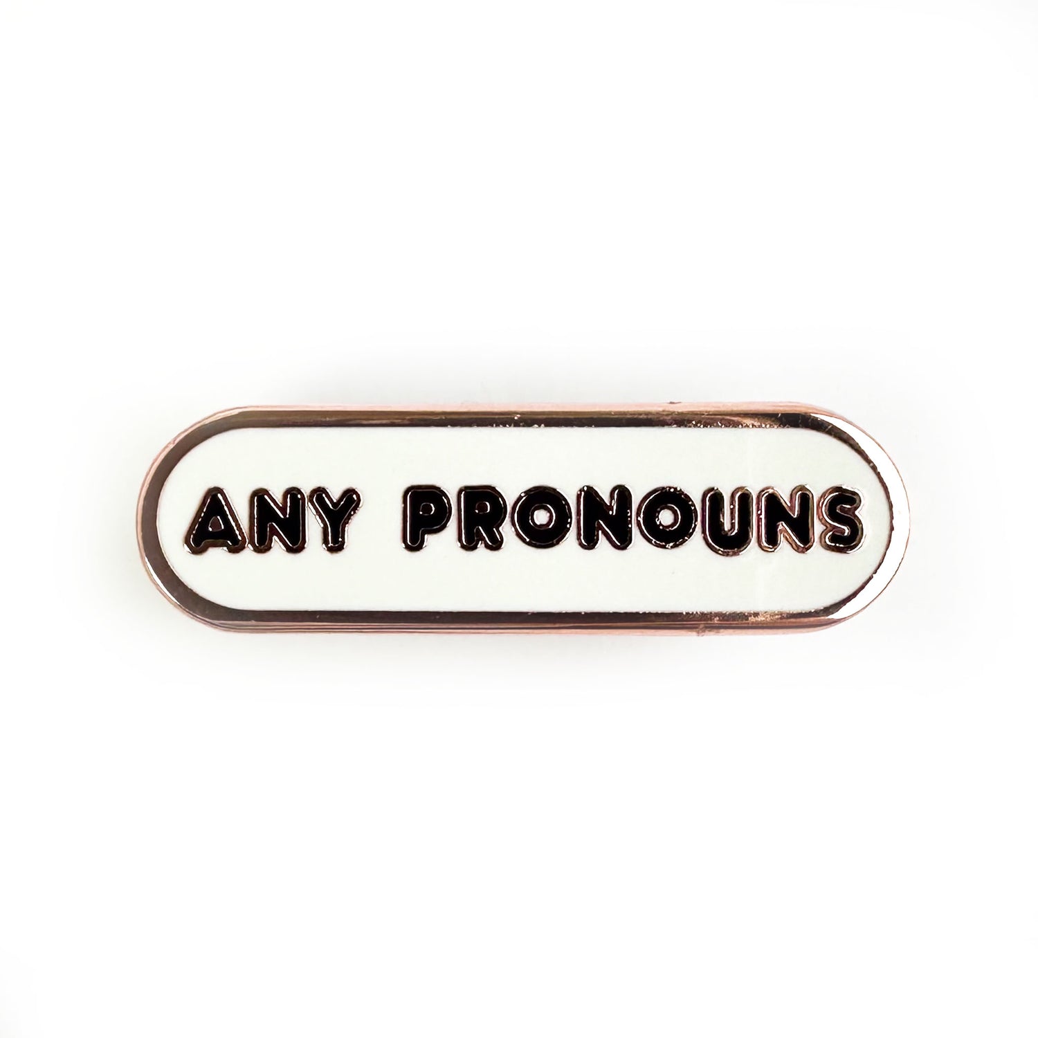 A white bandaid shaped pin with the words "any pronouns" on it.