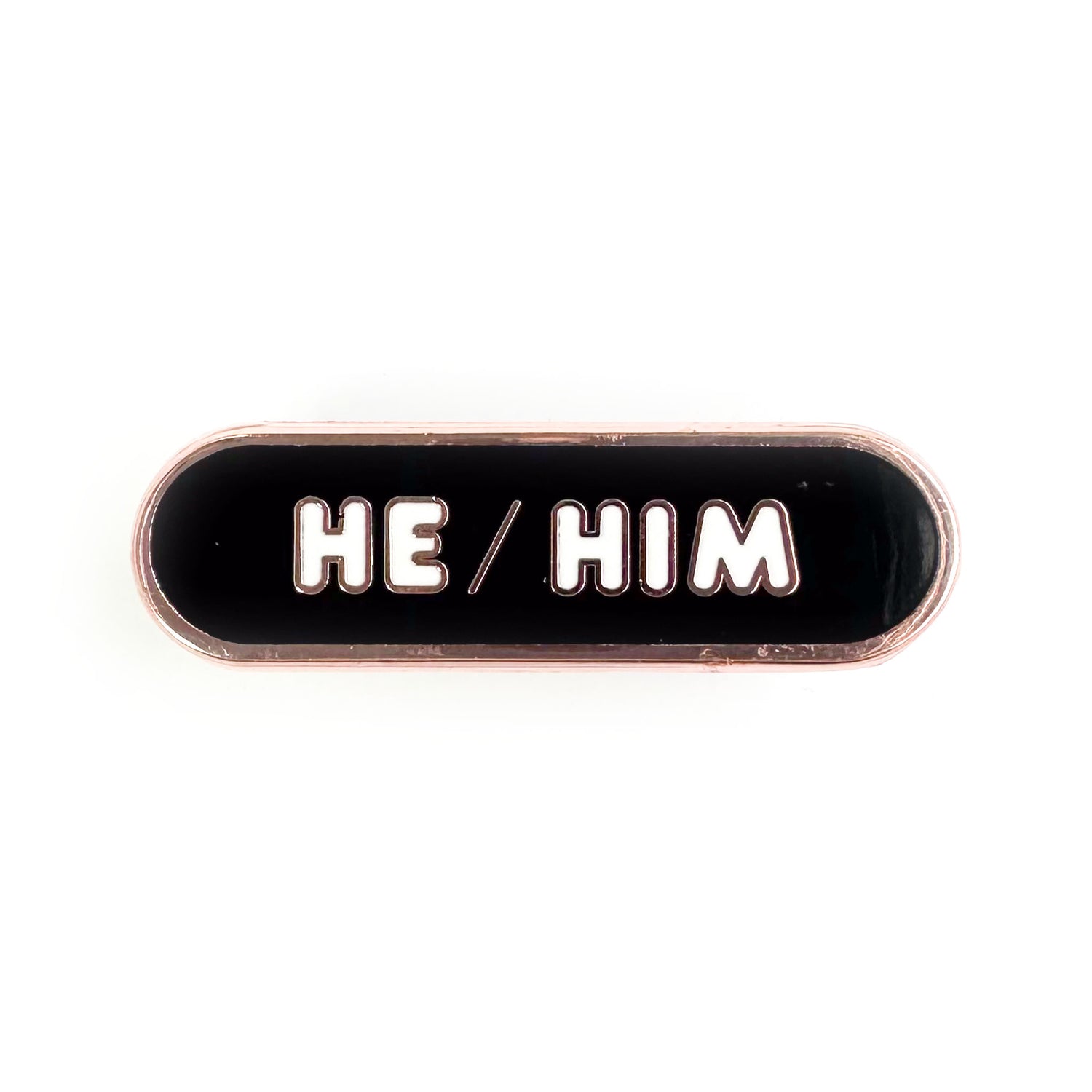A black capsule shaped pin that reads "He/Him".