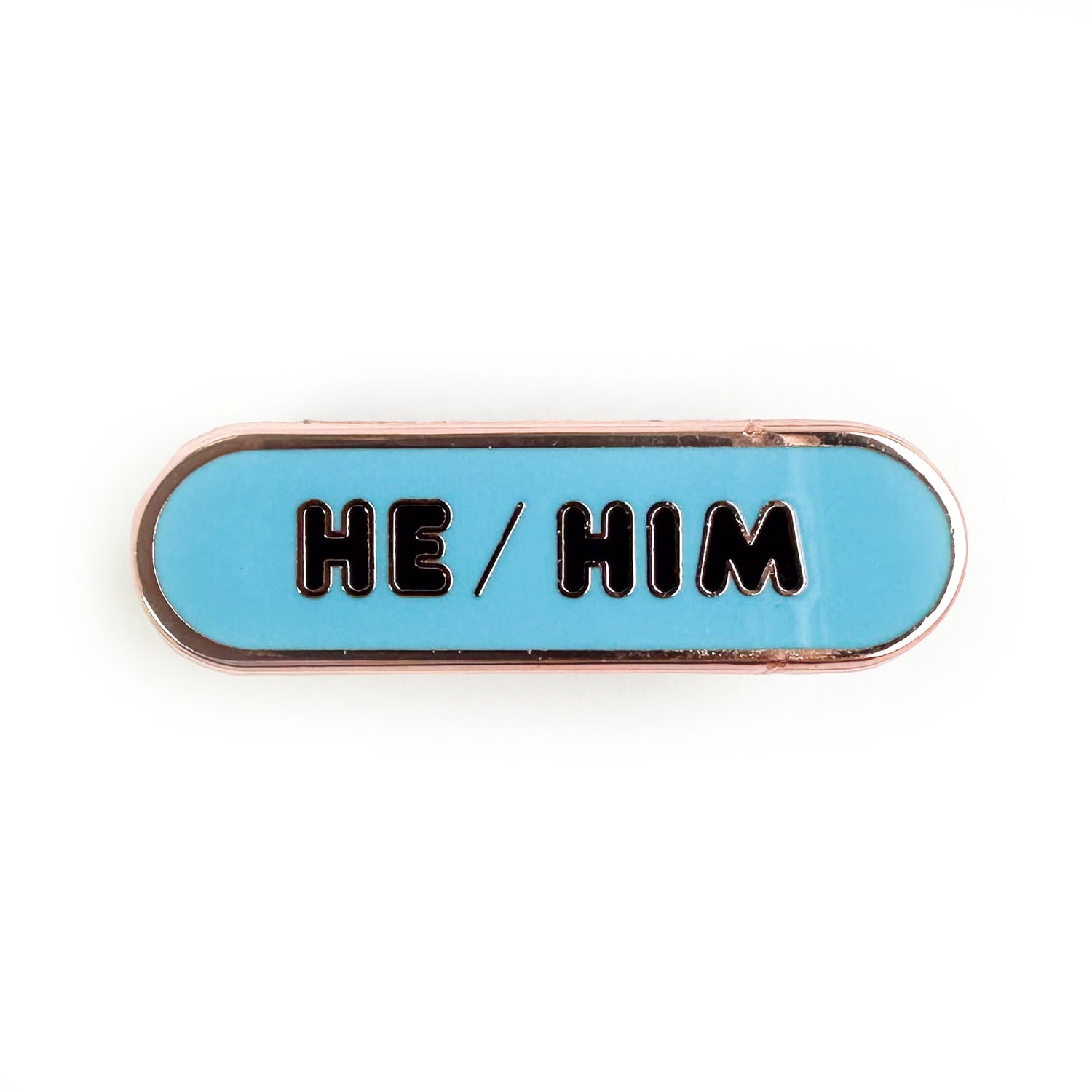 A light blue oval shaped pin that reads "He/Him".