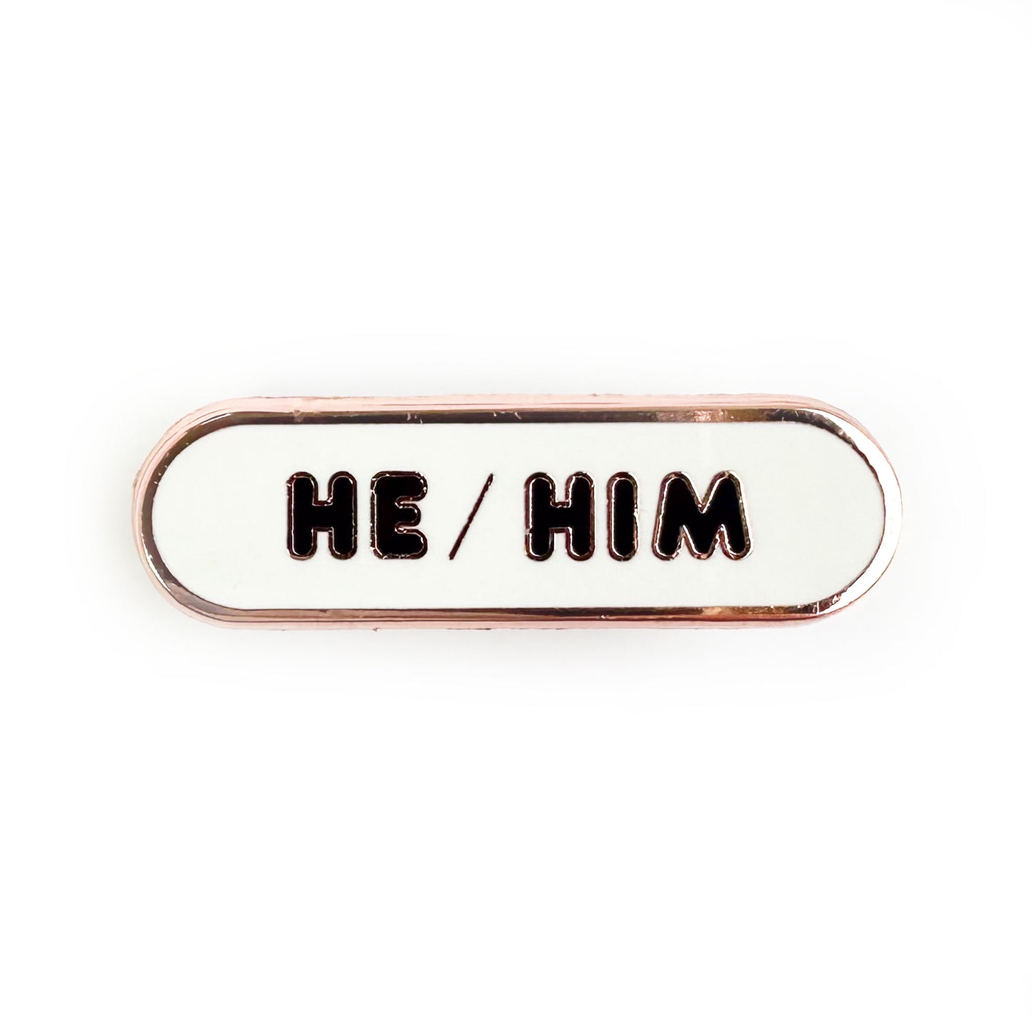 A white capsule shaped pin that reads "He/Him".