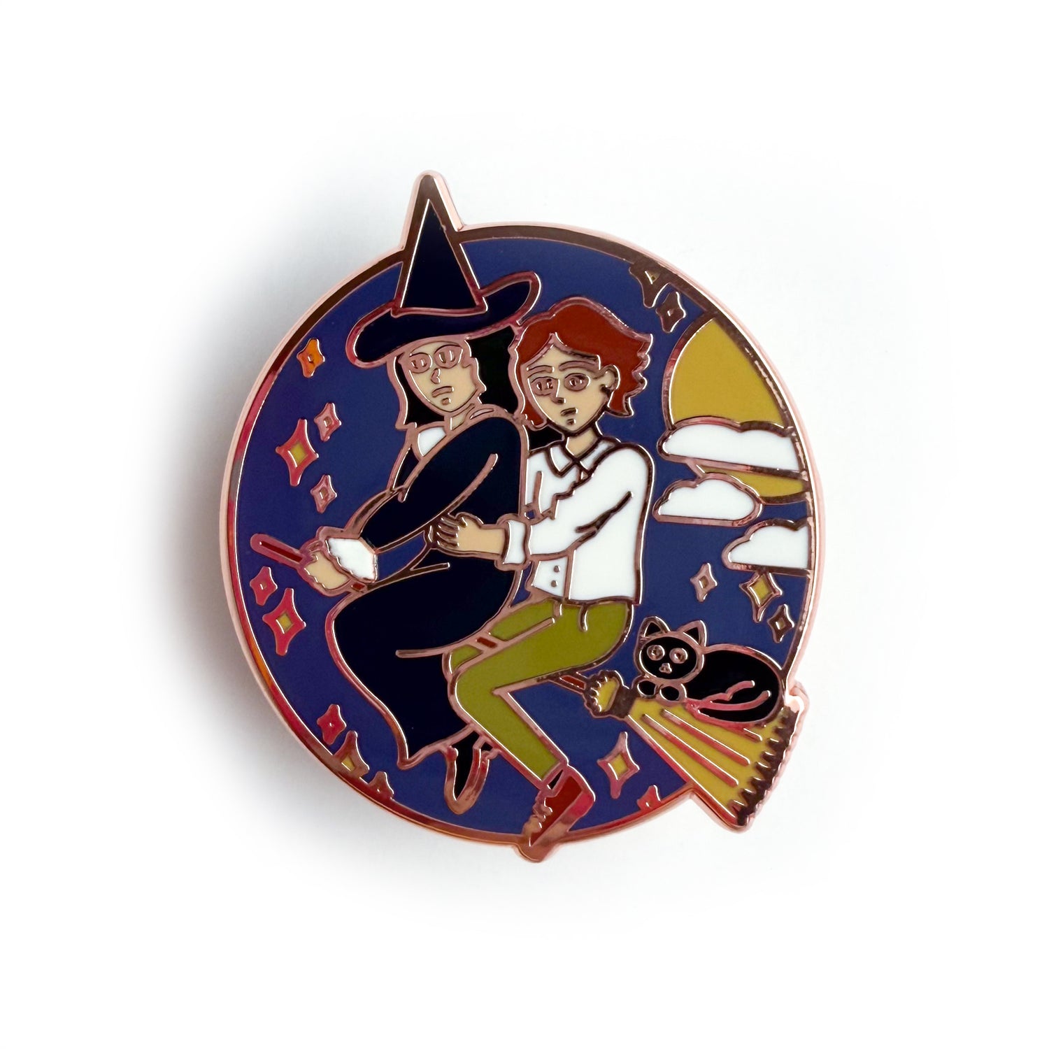An enamel pin featuring Verity and Tacita flying away together on Verity's broom. Verity's cat-who-is-not-a-cat familiar, Jack is riding with them! There are stars, clouds, and the moon surrounding them in a circle.