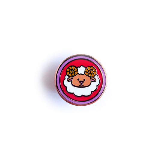 A circular enamel pin with a cute ram depicted on it to represent the Aries zodiac sign.