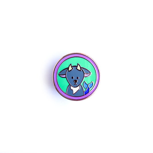A circle enamel pin with a cute illustration of a sea goat to represent Capricorn as a zodiac sign.