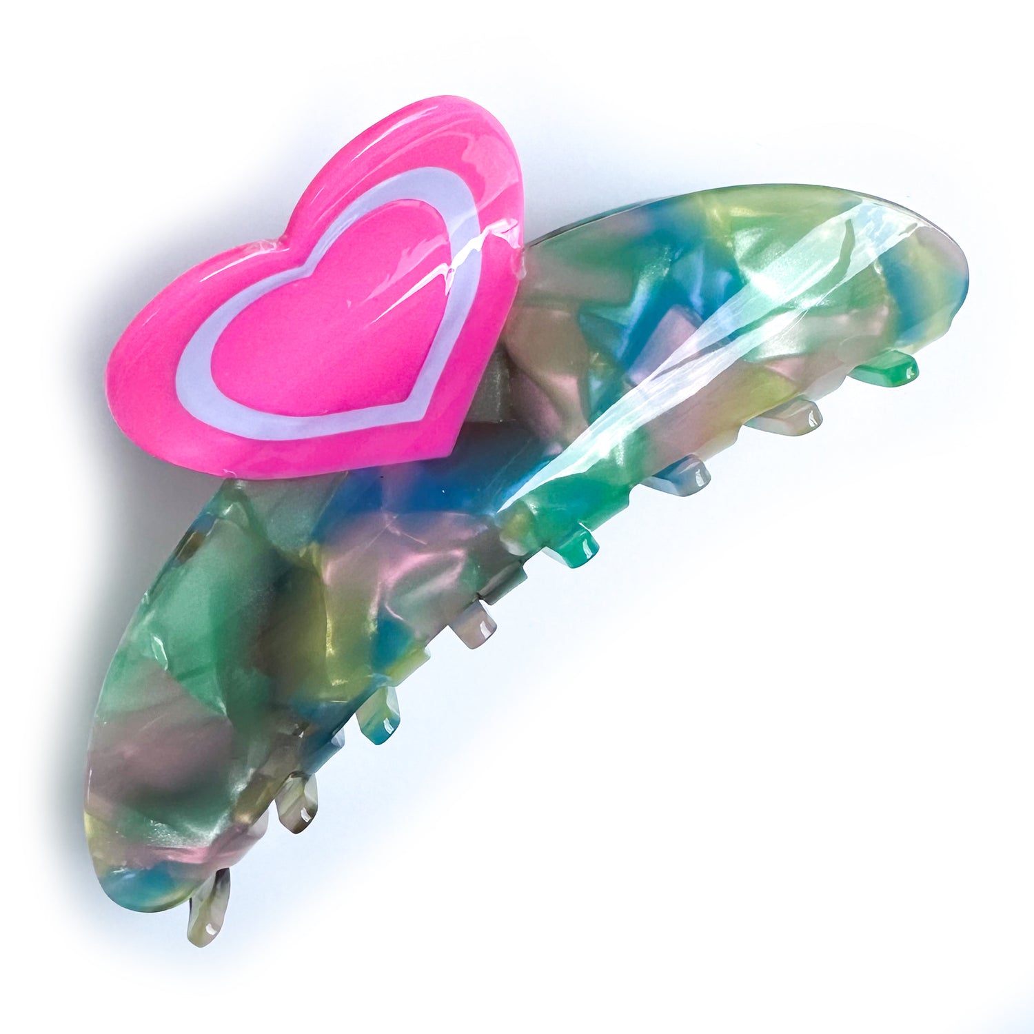 A claw clip with swirled pearly acetate in pink, blue, and yellow with a heart shaped handle. 