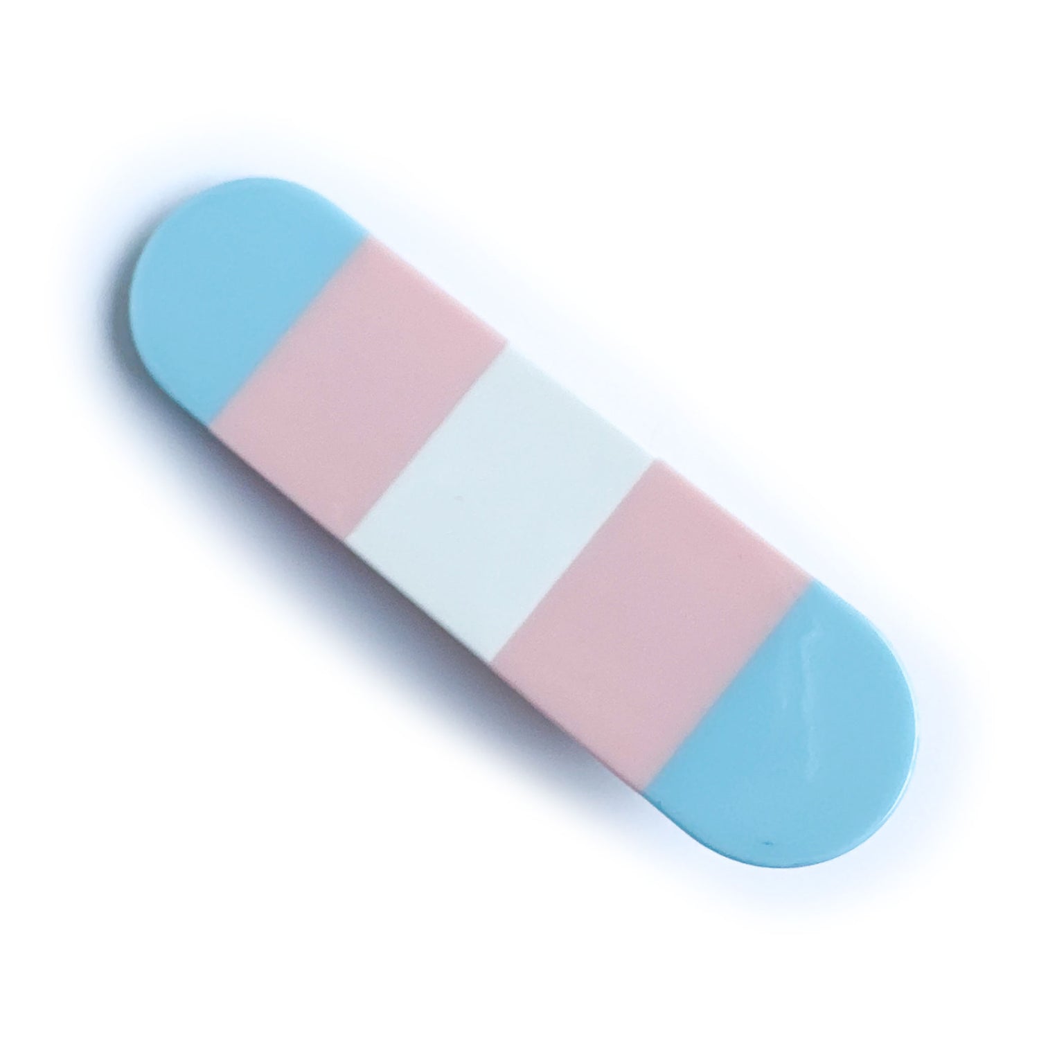 A capsule shaped hair clip with vertical stripes in the colors of the transgender pride flag. 