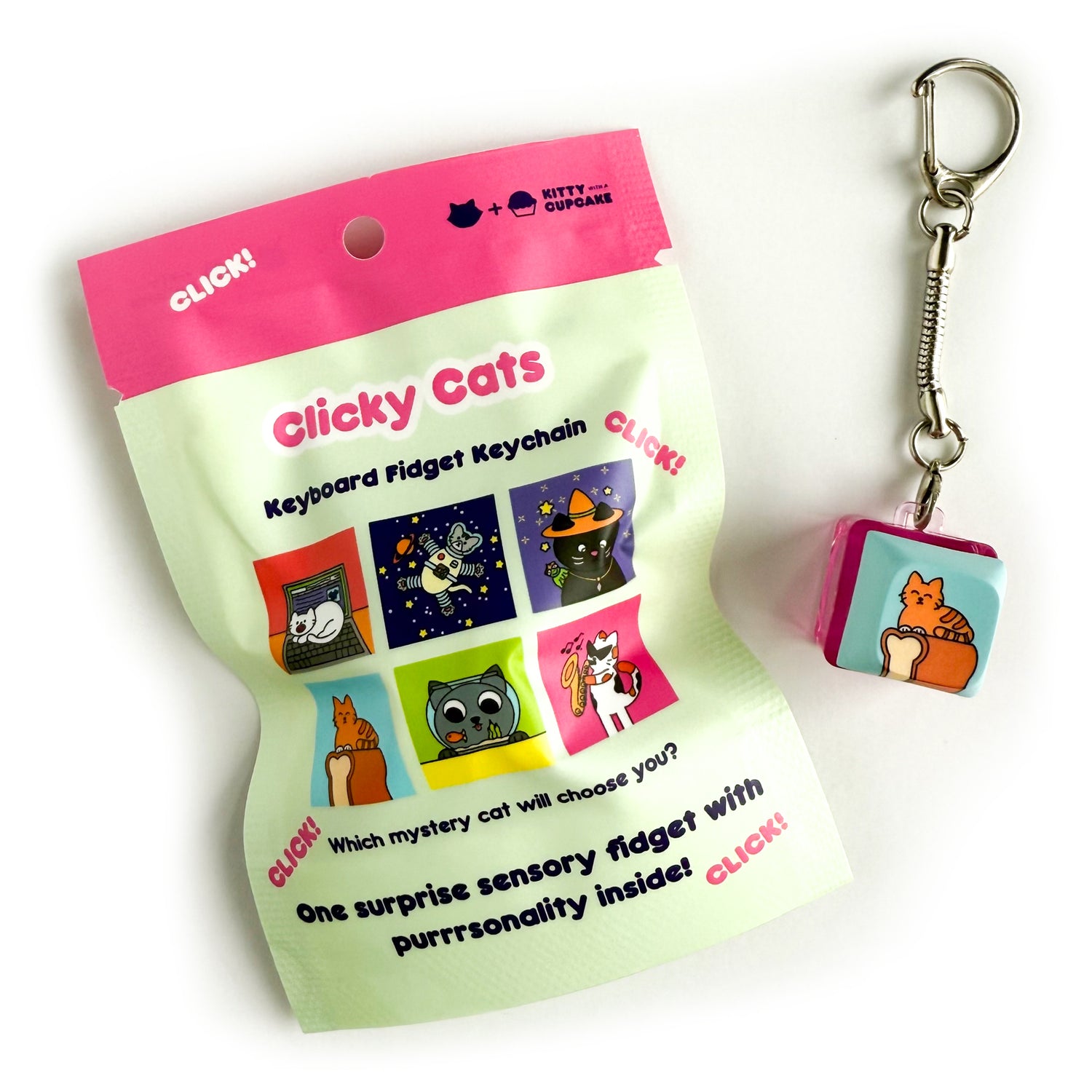 A square clicky keychain with a keycap that has an illustration of an orange cat on top of a loaf of bread on a blue background. There is a mint bag with a pink top that reads "Clicky Cats - Keyboard Fidget Keychain" and has pictures of different keychain designs all featuring cats. There is a Keyboard cat, Astronaut Cat, Witch Cat, Loaf Cat, Fishbowl Cat, and a Jazz Cat. The bottom of the bag reads "One surprise sensory fidget with purrrsonality inside!" 
