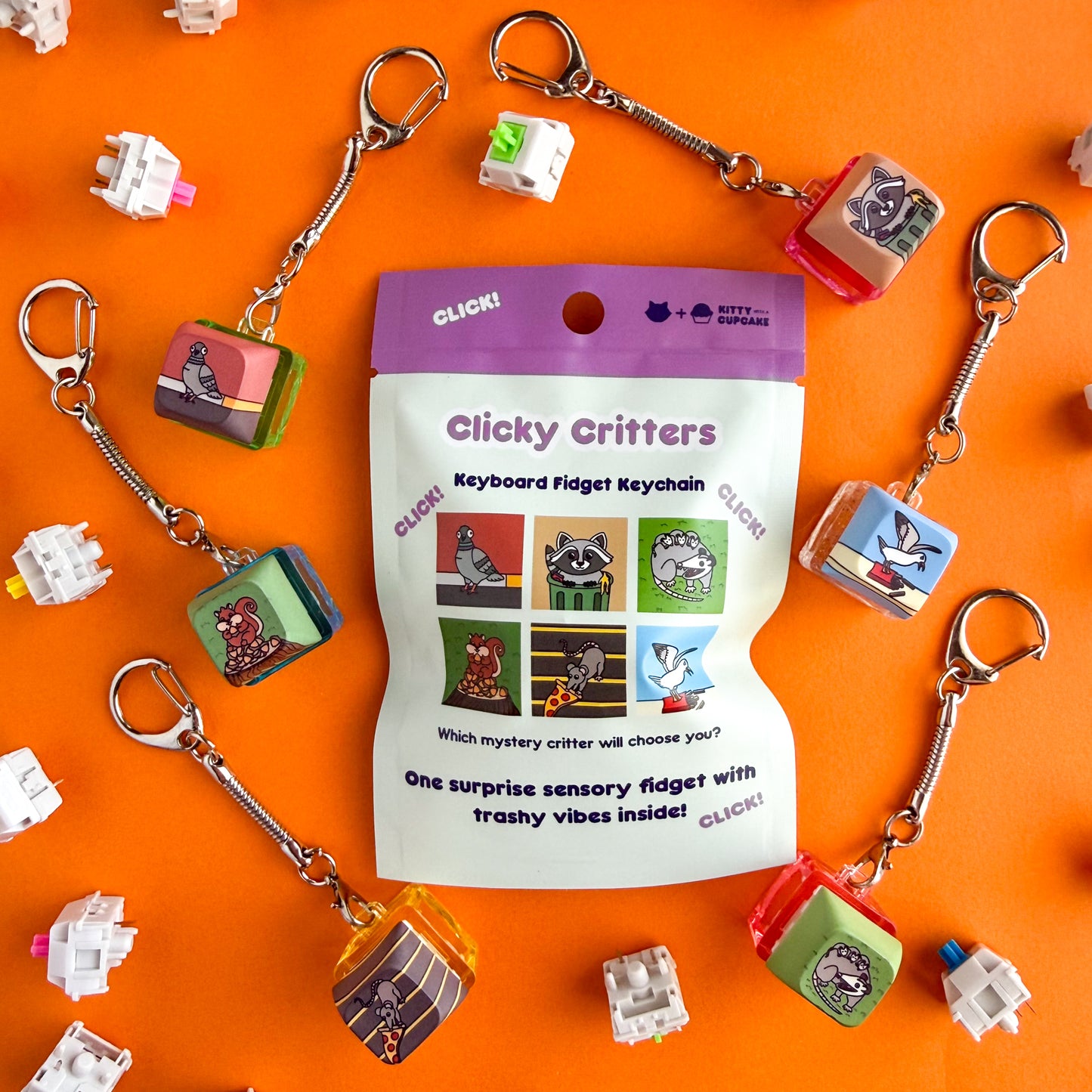 A blind bag that reads "Clicky Critters Keyboard Fidget Keychain" with illustrations of the different possibilities inside. The actual keychains are around the the bag and feature a pigeon, squirrel, pizza rat, raccoon, seagull and an opossum. This is all on an orange background. 