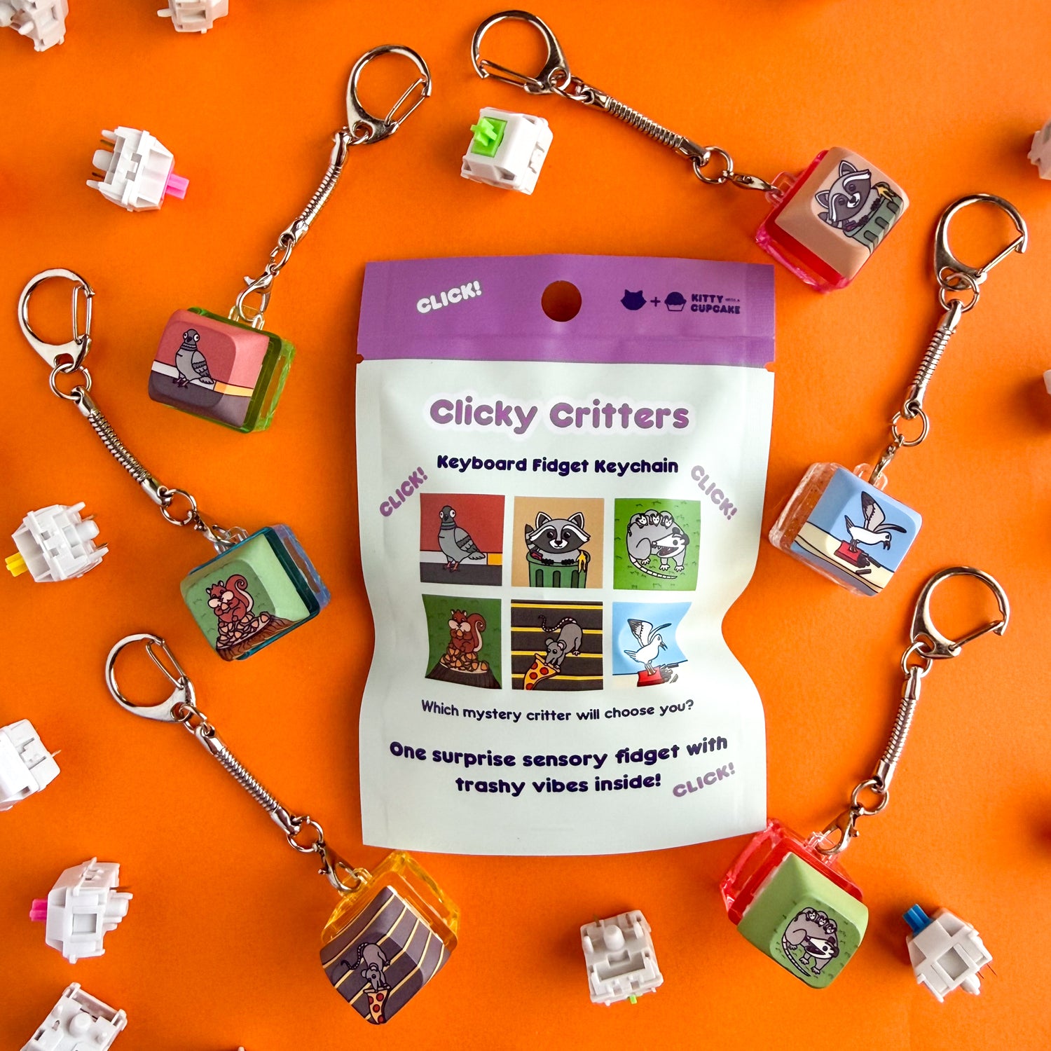 A blind bag that reads "Clicky Critters Keyboard Fidget Keychain" with illustrations of the different possibilities inside. The actual keychains are around the the bag and feature a pigeon, squirrel, pizza rat, raccoon, seagull and an opossum. This is all on an orange background. 