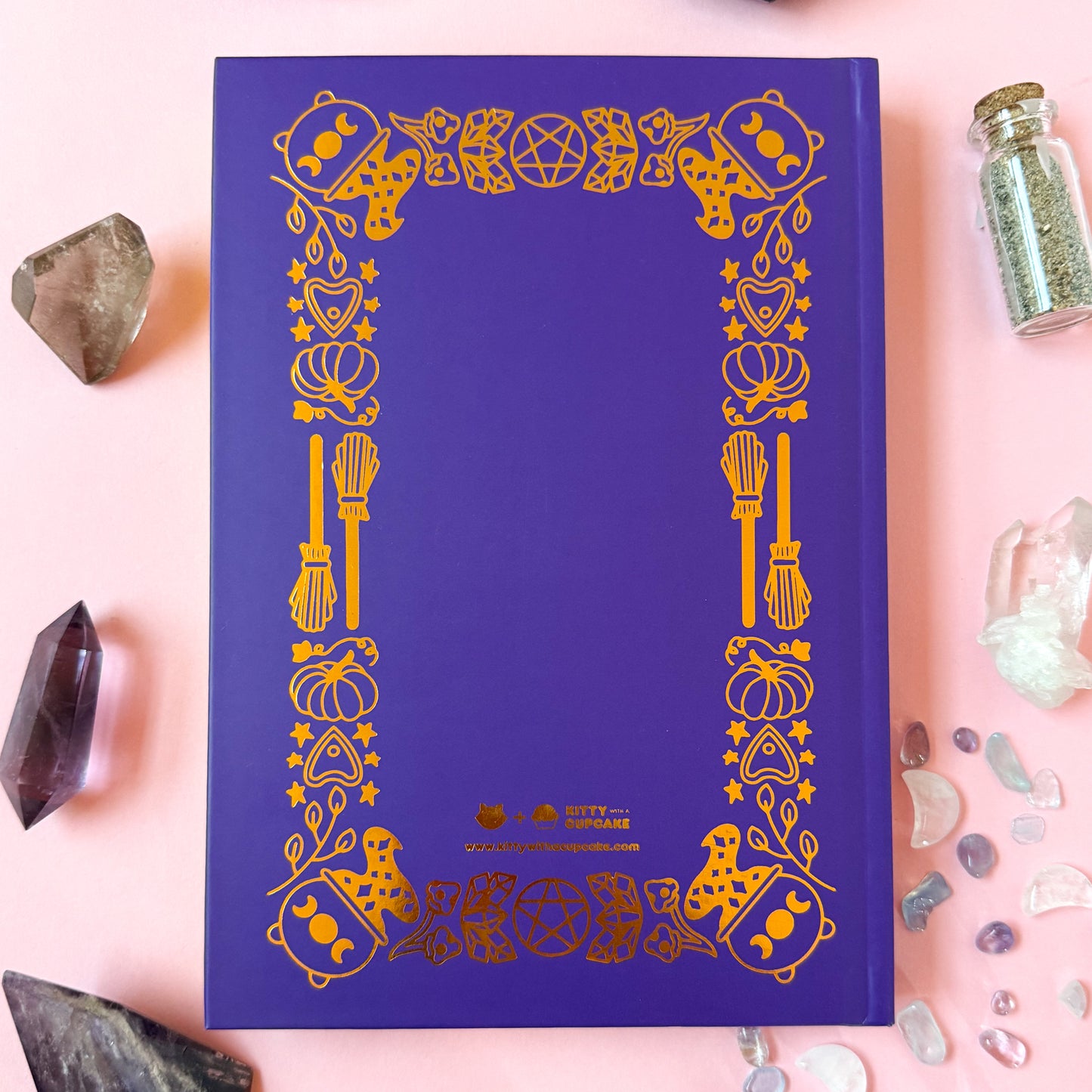 The back of the Book of Spells displayed surrounded by crystals and spell jars.