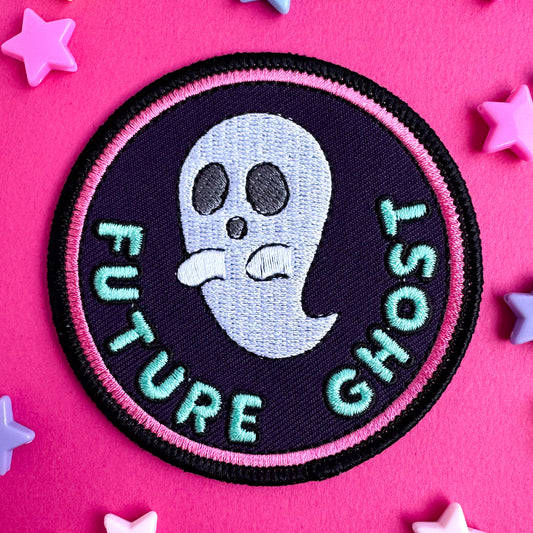 A circular embroidered patch that has a pink border with a cute ghost illustration on it and bubble letters that read "Future Ghost" 