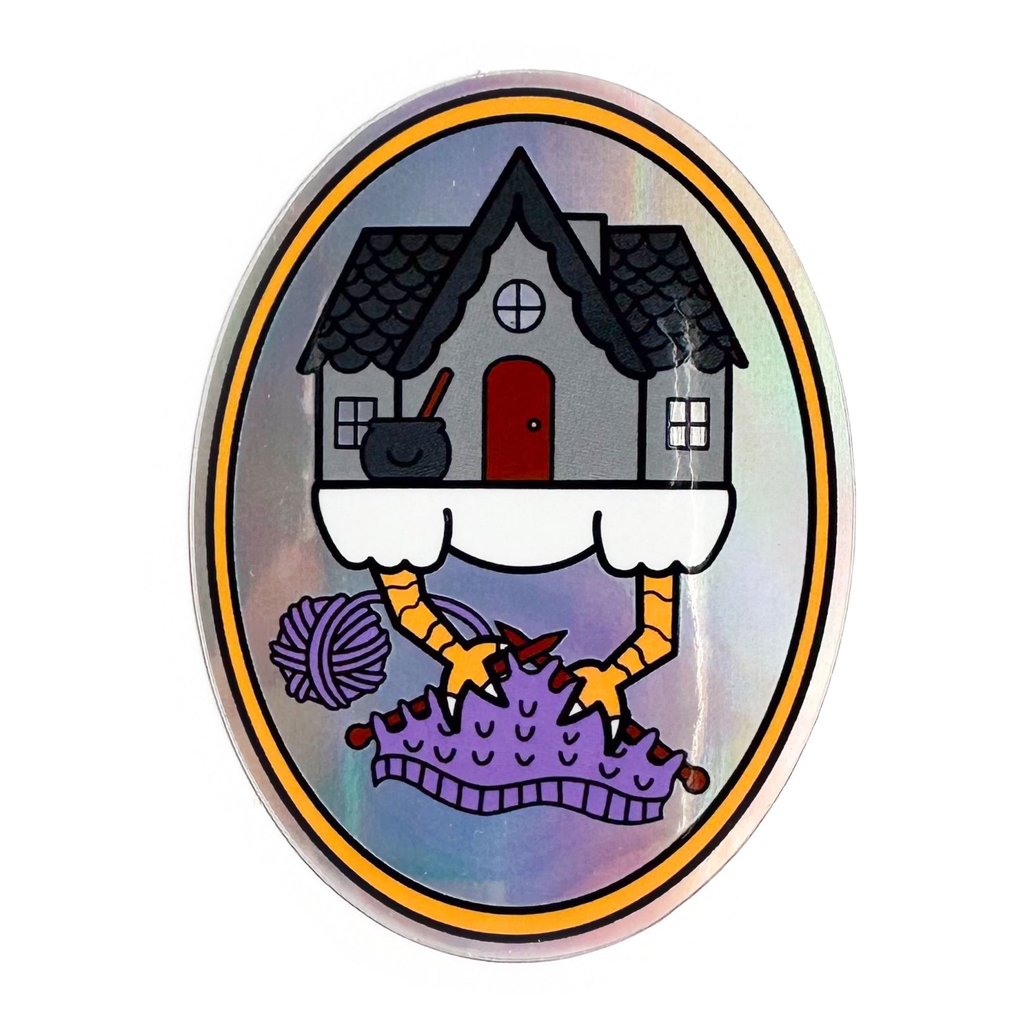 An oval shaped sticker with a cute illustration of Baba Yaga's house knitting on a purple project. The sticker has a holographic effect in the background. 