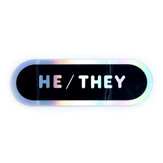 An oval shaped sticker with holographic bubble letters on a black background that read "Hey/They"