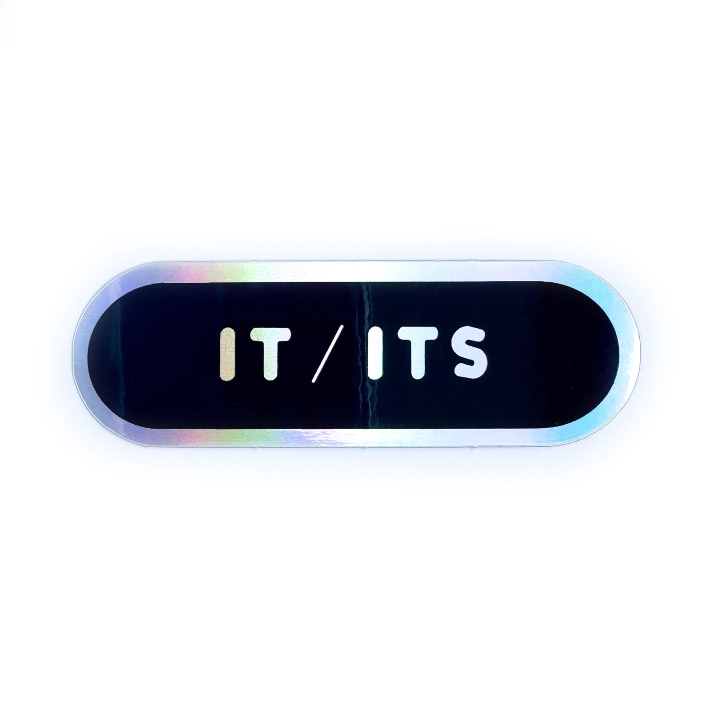 A capsule shaped holographic sticker that reads "it/its".