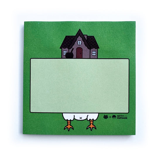 A square pad of green sticky notes featuring an illustration of Baba Yaga's hut surrounding a light green box which is an area to write in.