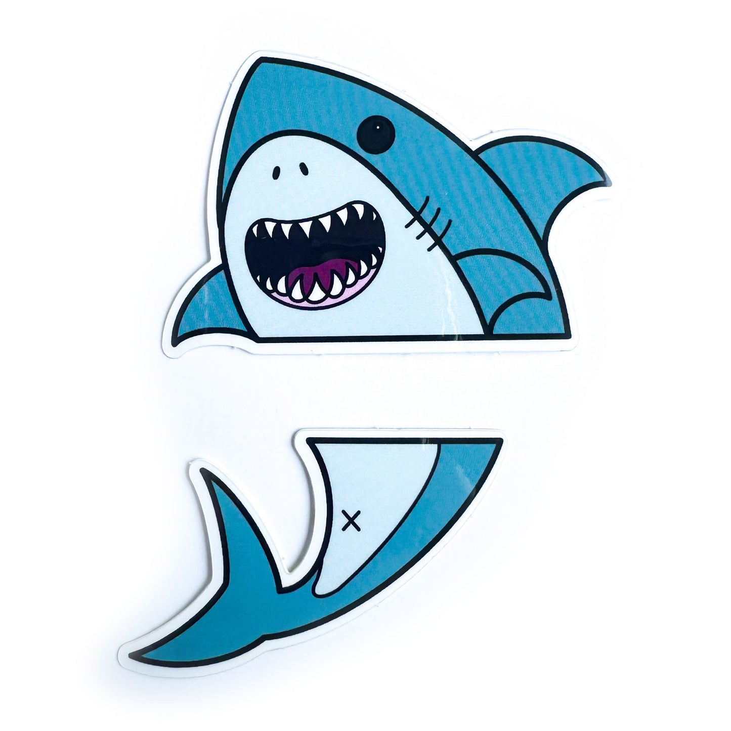 Two vinyl stickers that come together to form a cute illustration of a shark that is divided horizontally. 