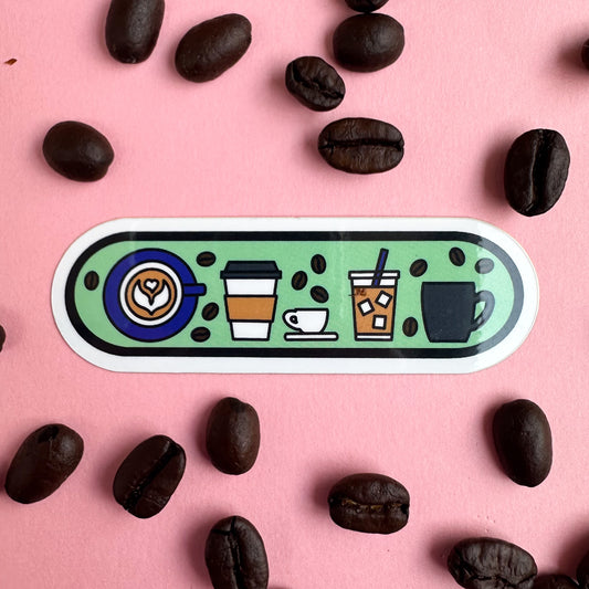 A capsule shaped sticker with illustrations of different coffee drinks on it including a latte with latte art, to-go hot drink, espresso cup, iced coffee and coffee mug. There are little coffee beans around these drinks. The pin is on a pink background with with real coffee beans around it.