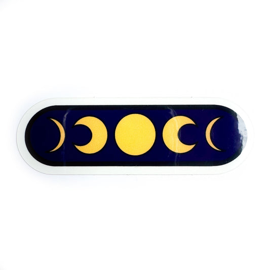 An oval shaped sticker with a dark purple background with yellow phases of the moon on it.