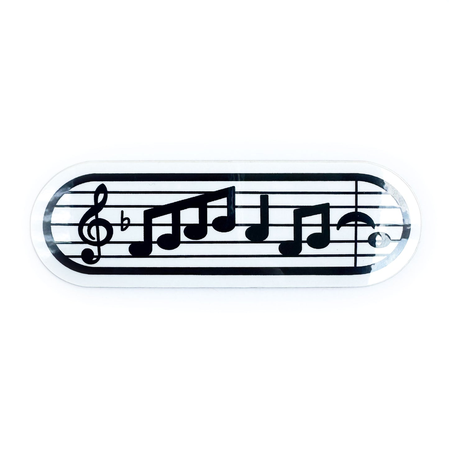 A capsule shaped vinyl sticker with a couple bars of music notation on it with a treble clef. 