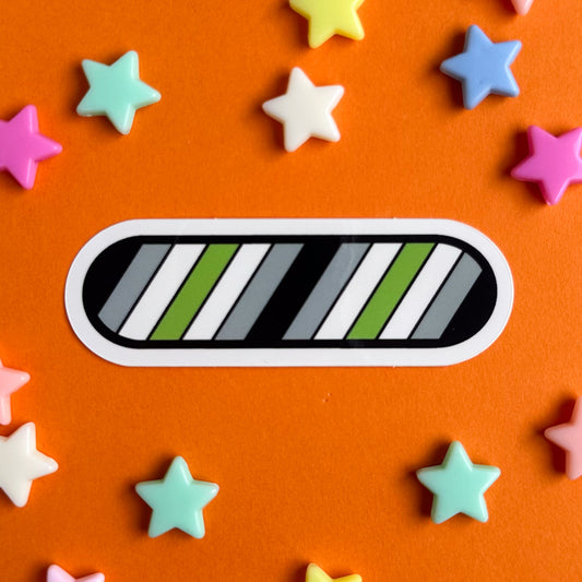 A vinyl sticker in the colors of the Agender flag. The sticker is on an orange background with star beads around it.