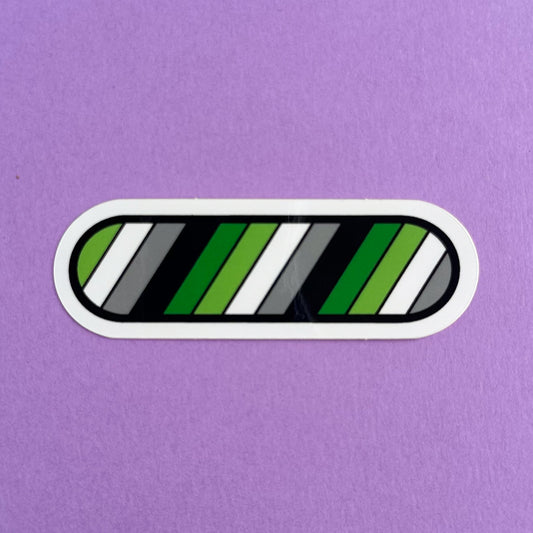 A capsule shaped vinyl sticker in the colors of the Aromantic pride flag on a purple background
