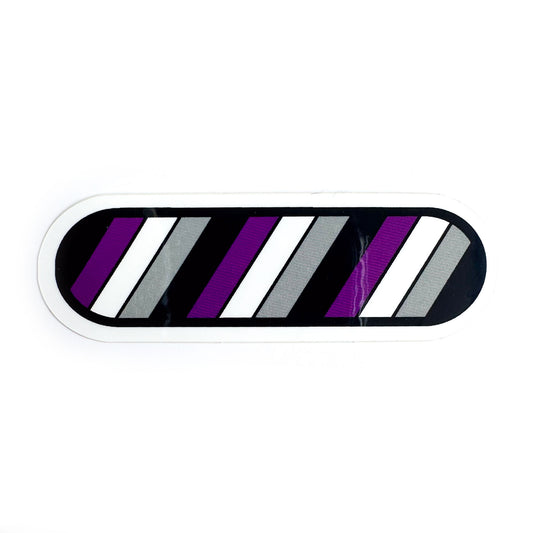 A capsule shaped vinyl sticker in the colors of the Asexual pride flag. There are diagonal stripes of black, purple, white and grey.