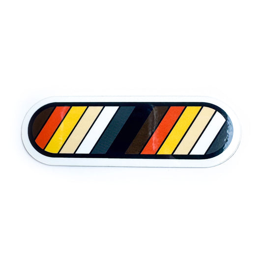 A vinyl sticker with diagonal stripes in the colors of the Bear Pride flag. The sticker is shaped like a capsule. 