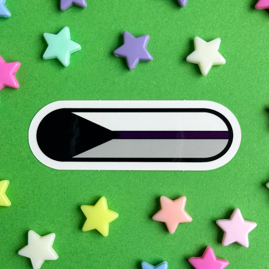 A capsule shaped sticker with the image of the Demisexual pride flag on it. The sticker is on a green background with pastel star beads around it.