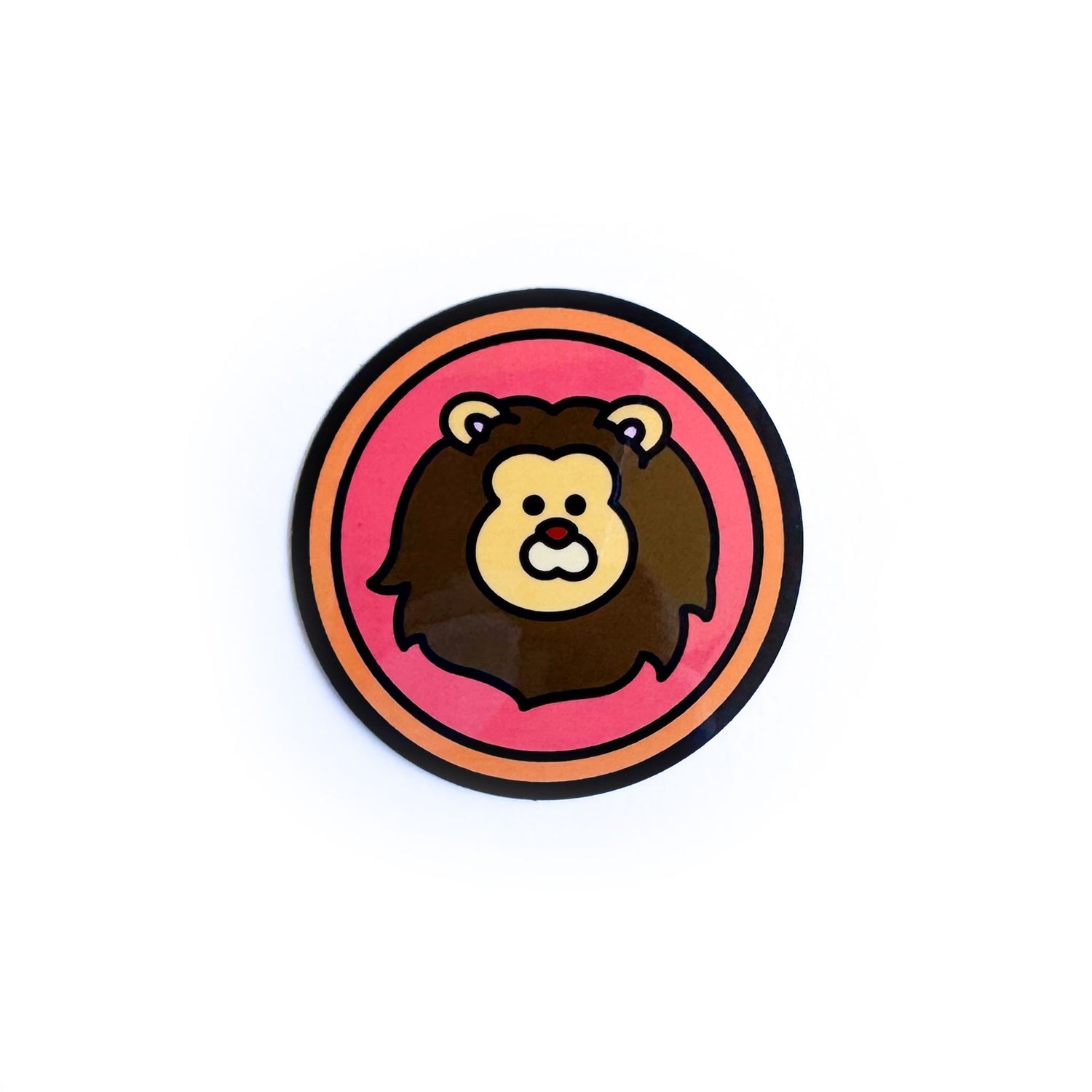 A sticker of a red circle with an orange border and an illustration of a lion in it to represent the Leo zodiac sign.  