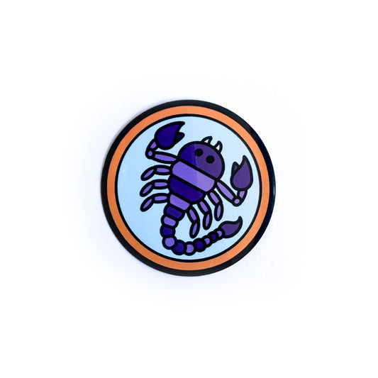 A circle sticker with a purple scorpion in it meant to symbolize the Scorpio zodiac sign.