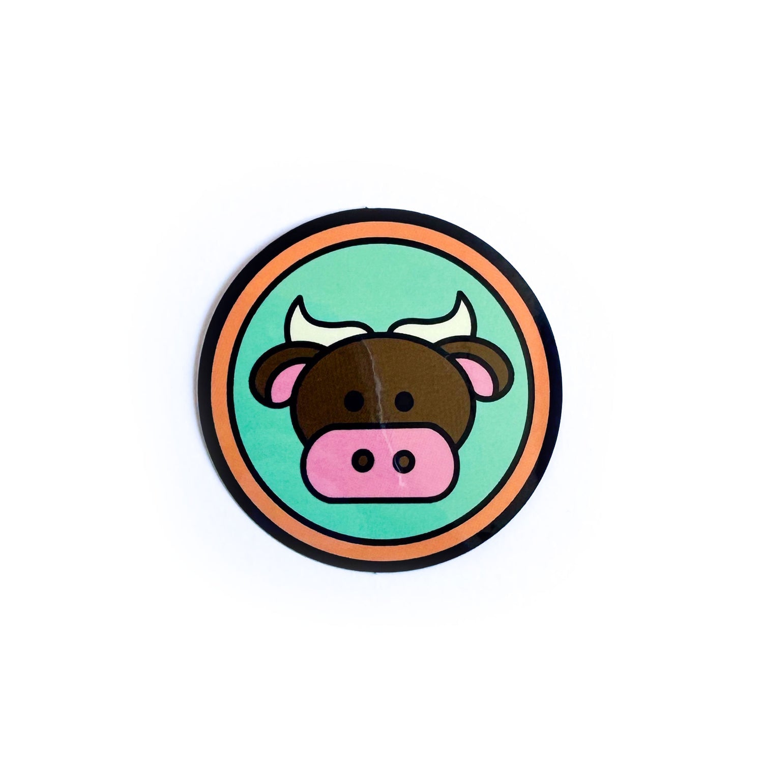 A circle sticker with a cute illustration of a bull on it to represent the Taurus zodiac sign. 