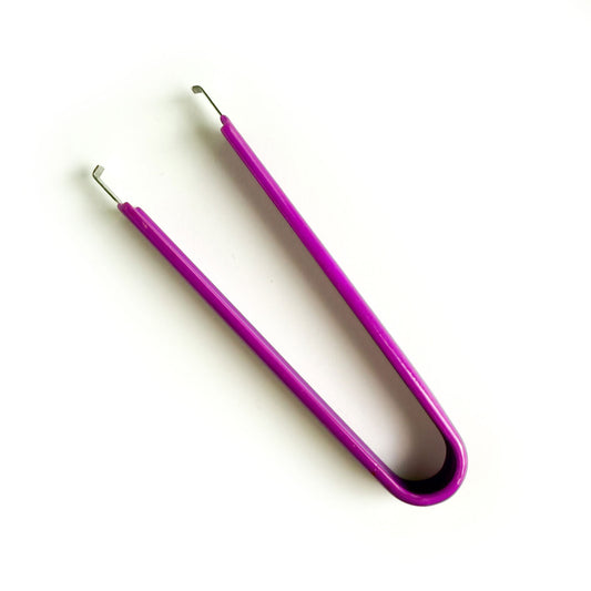 A purple switch puller tool for a mechanical keyboard. 