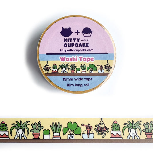 A circular roll of washi tape with a piece of the tape stuck below it, the design on the tape is illustrations of house plants sitting on a shelf with a yellow background.