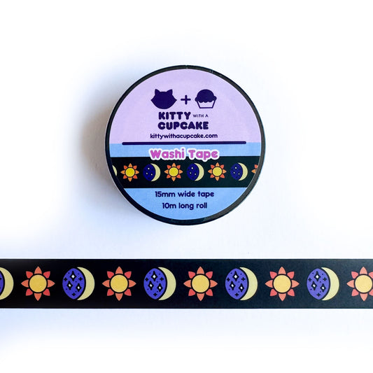 A roll of washi tape with a piece of the same tape below it. The tape is black with illustrative suns and moons on it.