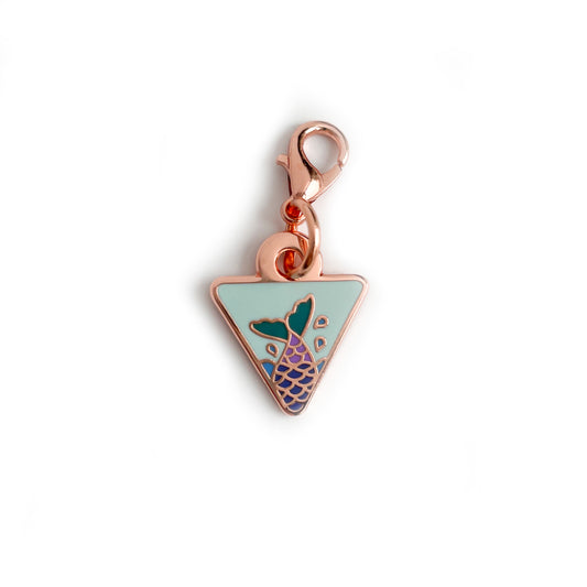 An upside down triangle charm with a lavender mermaid tail on it. 