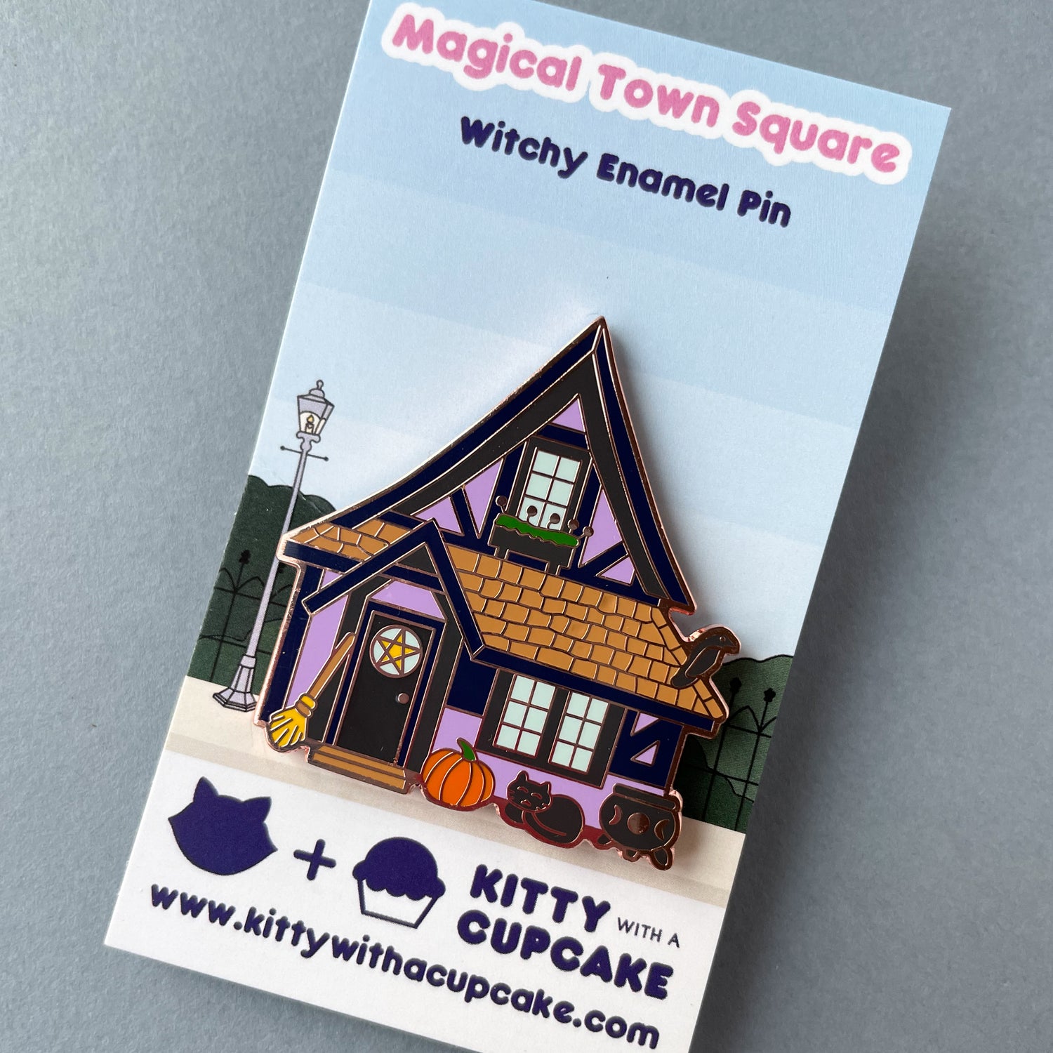 A purple house pin on a backing card that reads "Magical Town Square Witchy Enamel Pin". 