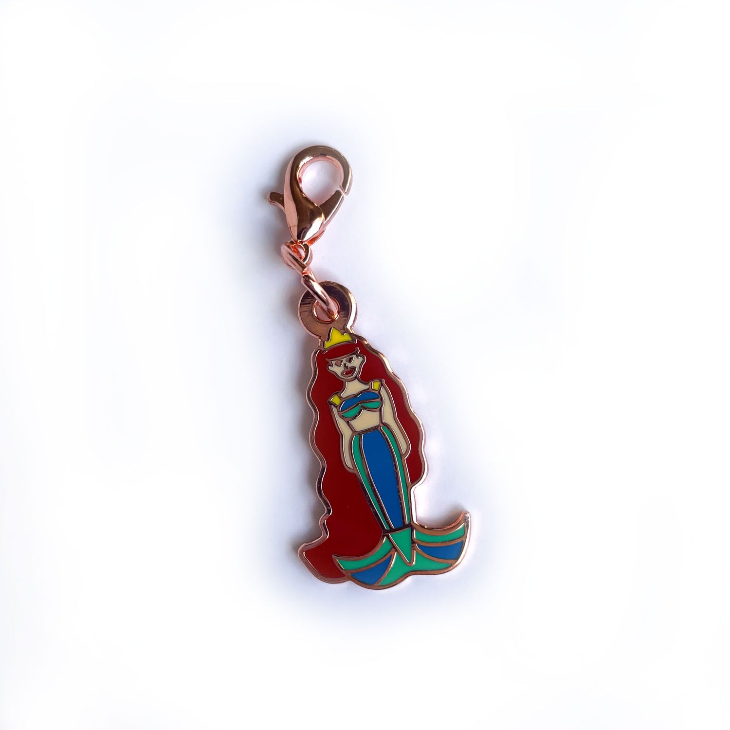 A lobster claw clasp charm shaped like a mermaid with long red hair and a green tail. 