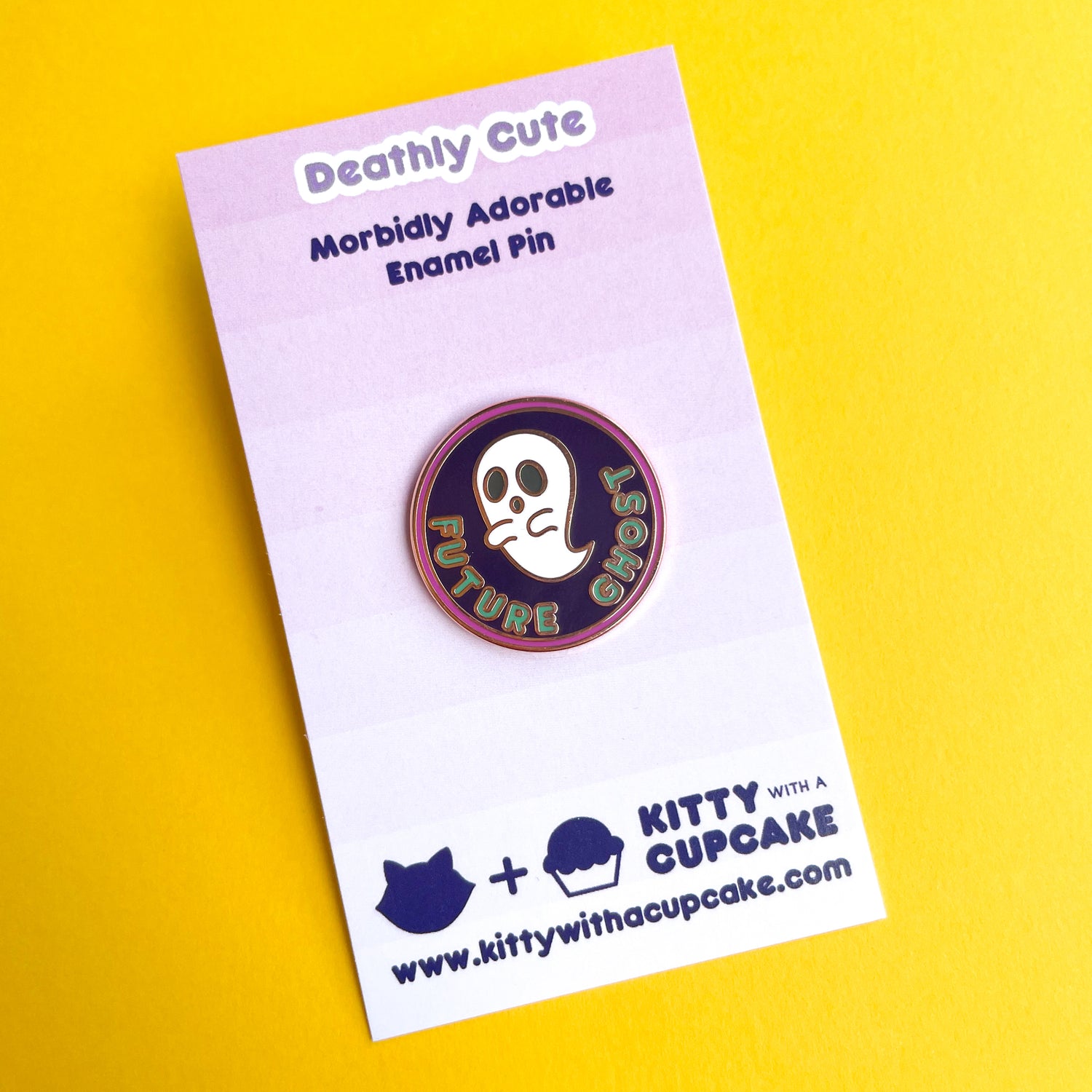 An circular enamel pin with a ghost on it that reads "Future Ghost" on a pink card.
