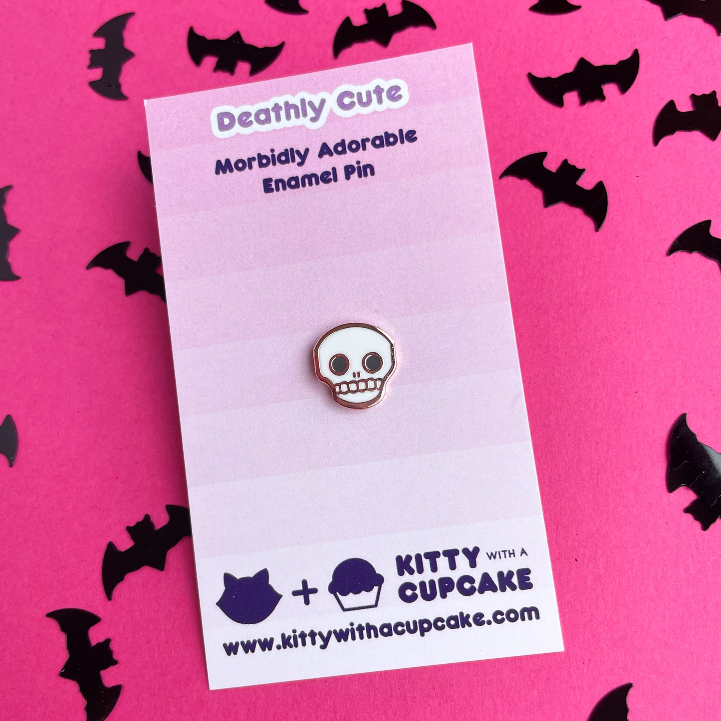 A cute skull pin on a pink card.