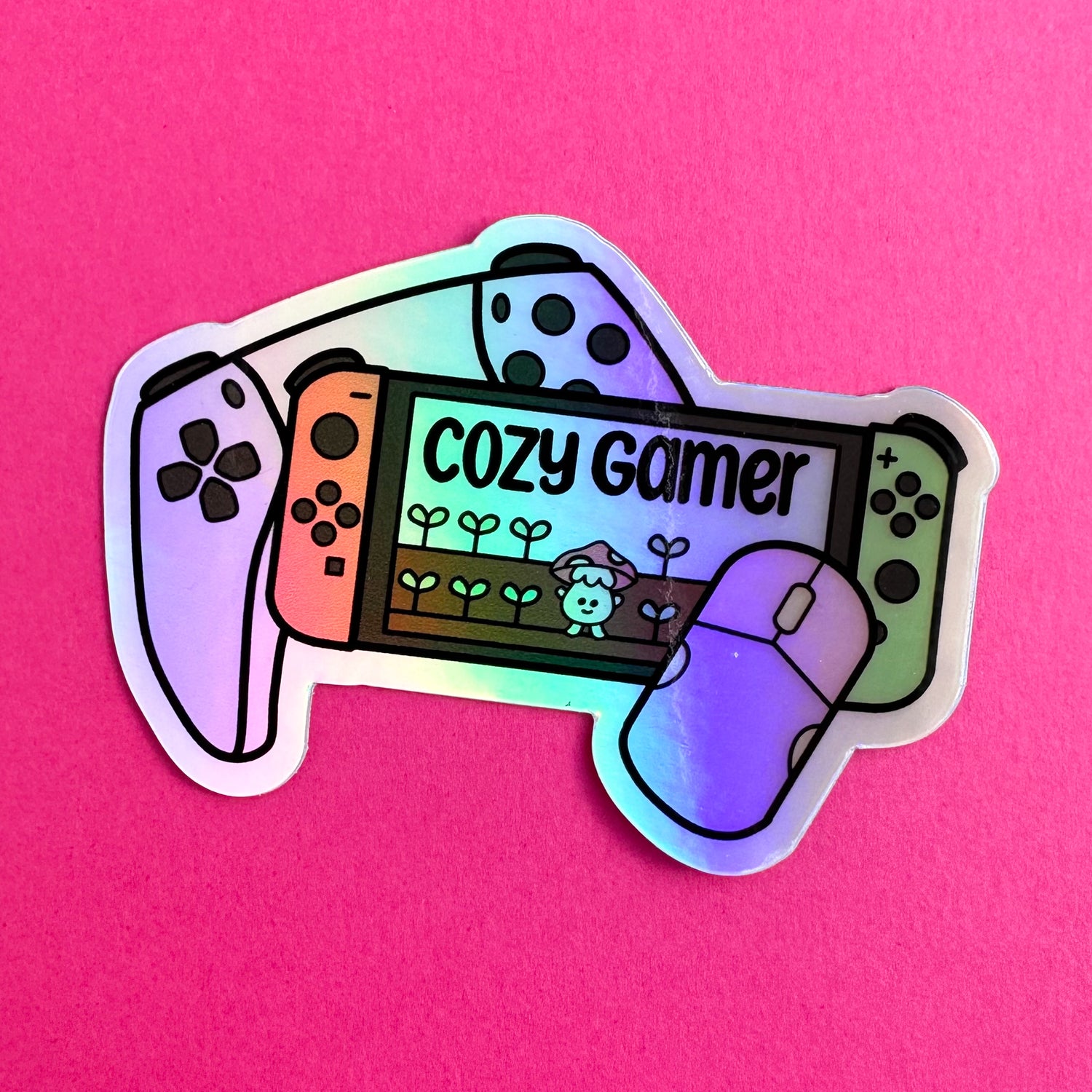 A Nintendo switch sticker that reads "cozy gamer" on a hot pink background.