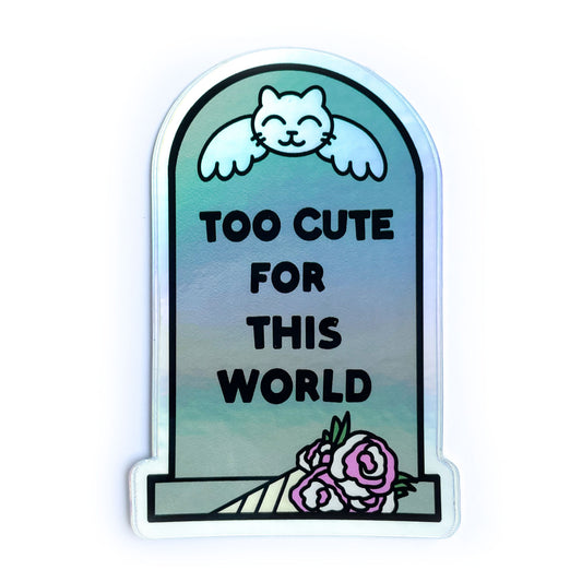 A headstone shaped holographic sticker that reads "Too Cute For This World" with a cat angle on it and a bouquet by it.