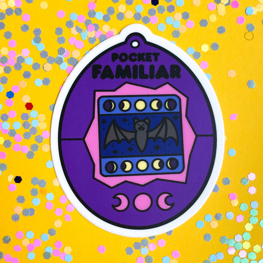 A purple virtual pet shaped sticker on a yellow background covered in pastel confetti.  