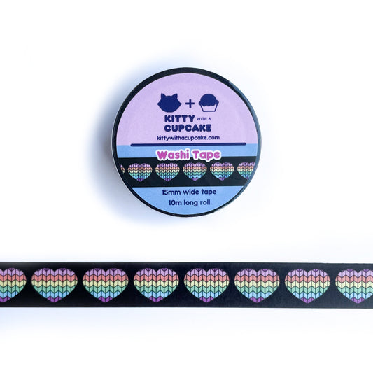 A roll of washi tape above a sample of that washi tape that has a black background with hearts with a pastel rainbow stockinette knit stitch pattern on them.